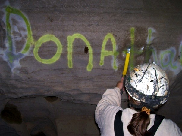 Cleaning cave graffiti.